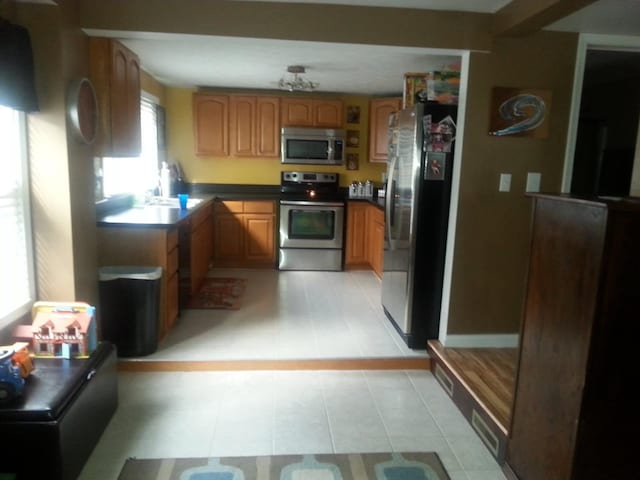 1111 Maple St, Staunton, VA 24401 - kitchen featuring appliances with stainless steel finishes, brown cabinetry, and dark countertops
