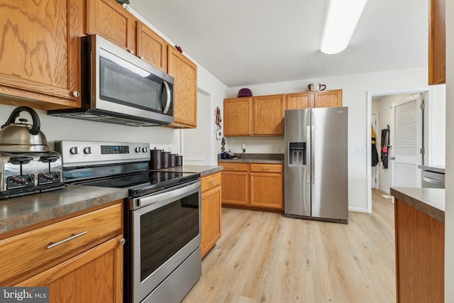 12224 Stonehenge Dr, Fredericksburg, VA 22407 - kitchen featuring appliances with stainless steel finishes, light wood-style flooring, and dark countertops
