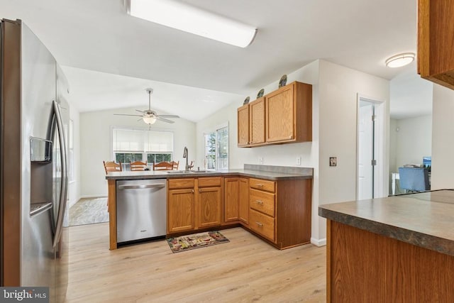 12224 Stonehenge Dr, Fredericksburg, VA 22407 - kitchen featuring appliances with stainless steel finishes, light wood-style flooring, a peninsula, dark countertops, and a sink