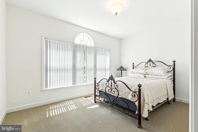 carpeted bedroom featuring visible vents and baseboards