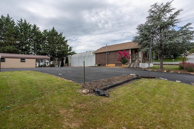 exterior space with driveway and a lawn