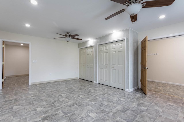 unfurnished bedroom featuring baseboards, recessed lighting, and two closets