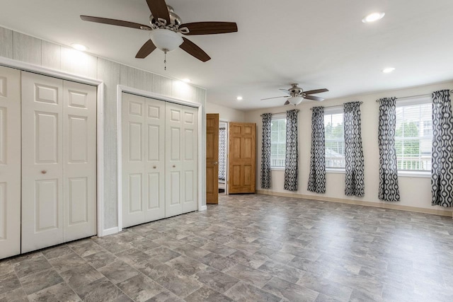 unfurnished bedroom with two closets, baseboards, a ceiling fan, and recessed lighting