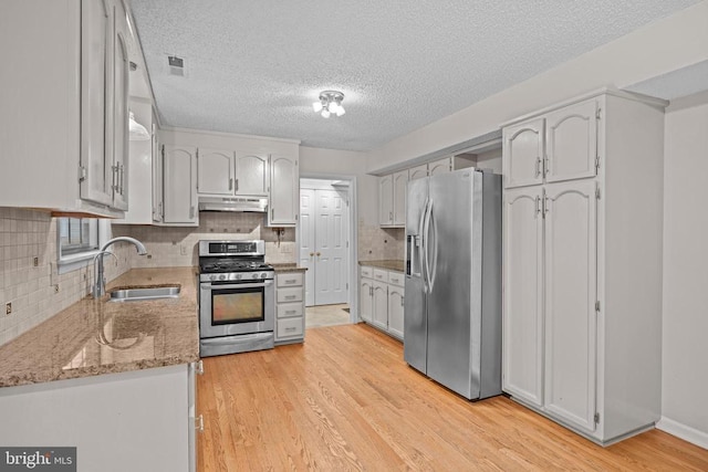 47 Marwood Dr, Palmyra, VA 22963 - kitchen featuring stainless steel appliances, under cabinet range hood, light stone countertops, a textured ceiling, and backsplash