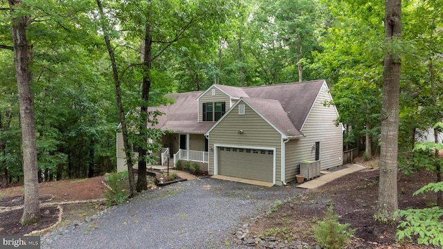 47 Marwood Dr, Palmyra, VA 22963 - view of front facade with an attached garage, covered porch, gravel driveway, a forest view, and a shingled roof