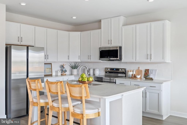 kitchen featuring stainless steel appliances, tasteful backsplash, white cabinets, and recessed lighting