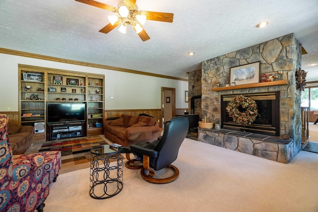 5090 Springhouse Cir, Rockingham, VA 22802 - carpeted living area with a wainscoted wall, crown molding, a textured ceiling, ceiling fan, and a stone fireplace