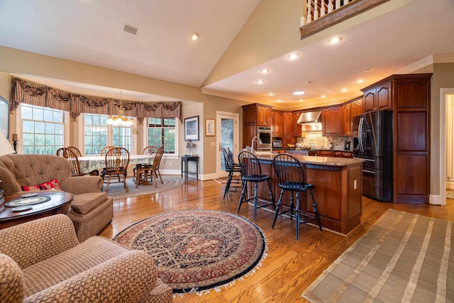 5090 Springhouse Cir, Rockingham, VA 22802 - kitchen featuring wall chimney range hood, a healthy amount of sunlight, black fridge, and a kitchen bar