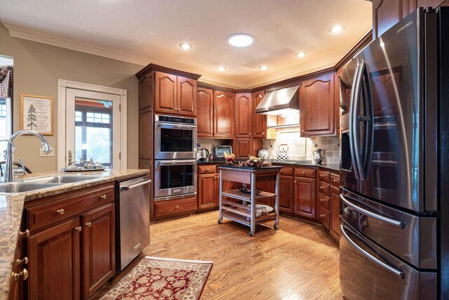 5090 Springhouse Cir, Rockingham, VA 22802 - kitchen with a sink, stainless steel appliances, wall chimney range hood, crown molding, and decorative backsplash