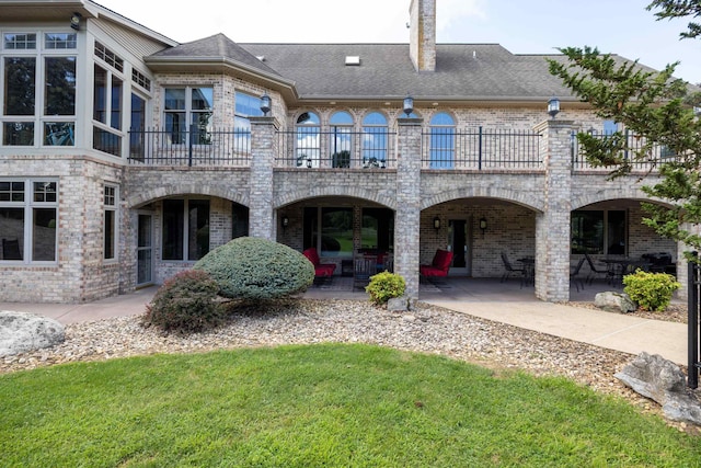 5090 Springhouse Cir, Rockingham, VA 22802 - rear view of property featuring a patio, brick siding, a lawn, and a balcony