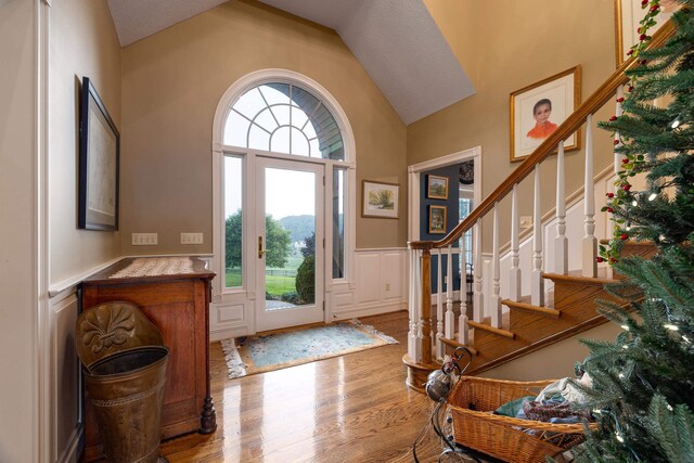 5090 Springhouse Cir, Rockingham, VA 22802 - entryway featuring a decorative wall, high vaulted ceiling, a wainscoted wall, wood finished floors, and stairway