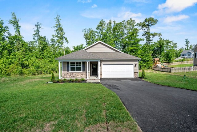 view of front of house with a garage, a front lawn, and a playground