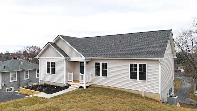 view of front of property with central AC and a front yard