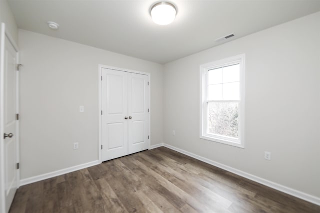 unfurnished bedroom with hardwood / wood-style flooring and a closet