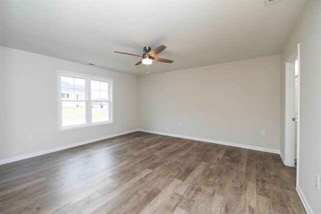 empty room with ceiling fan and dark hardwood / wood-style flooring