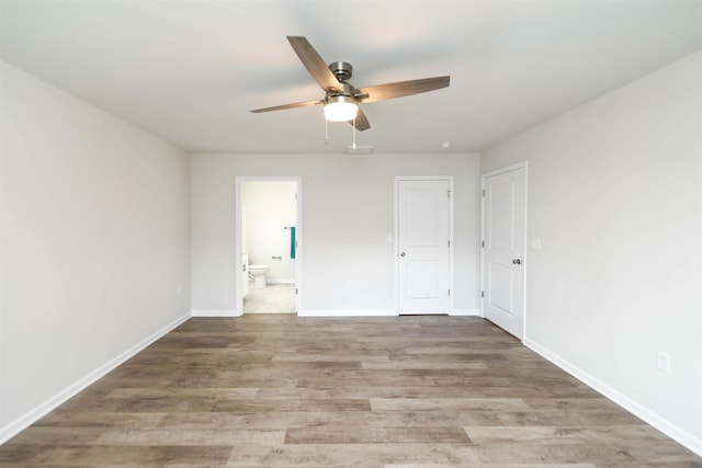 unfurnished bedroom featuring hardwood / wood-style flooring, ensuite bath, and ceiling fan