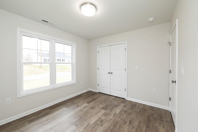 unfurnished bedroom with hardwood / wood-style floors and a closet