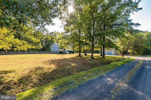  - view of front of property with dirt driveway and a garage