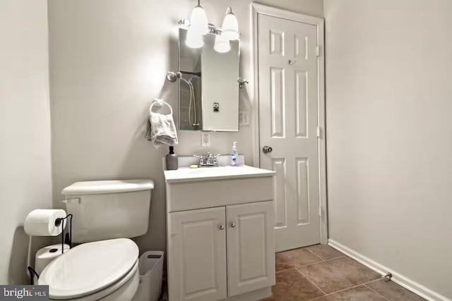 bathroom featuring tile patterned flooring, vanity, toilet, and baseboards