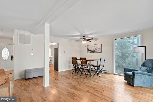 dining area featuring visible vents, baseboards, a ceiling fan, ornamental molding, and light wood finished floors