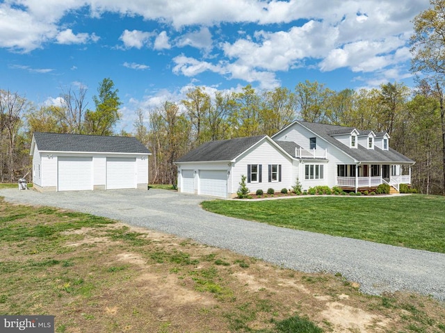  - view of front facade with a detached garage, a porch, a front lawn, and an outdoor structure