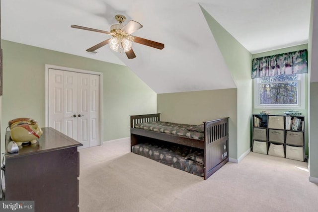  - carpeted bedroom with a closet, a ceiling fan, lofted ceiling, and baseboards