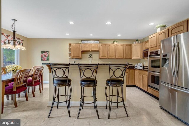  - kitchen featuring stainless steel appliances, recessed lighting, a breakfast bar, dark countertops, and baseboards