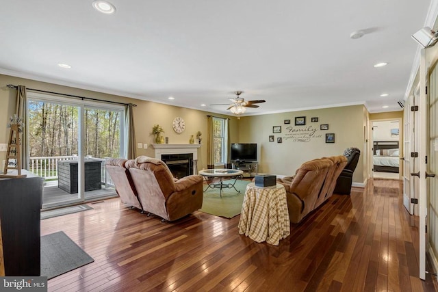  - living room with a glass covered fireplace, dark wood finished floors, ornamental molding, ceiling fan, and recessed lighting