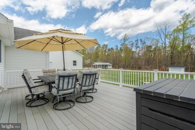  - wooden deck with outdoor dining space, a storage shed, and an outdoor structure