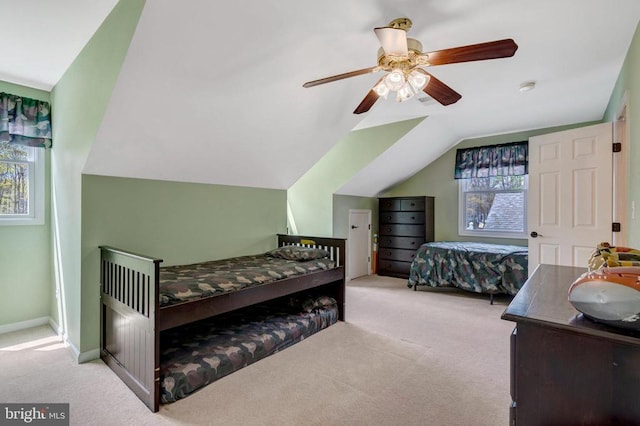  - carpeted bedroom with multiple windows, vaulted ceiling, a ceiling fan, and baseboards