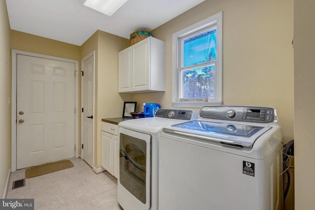  - clothes washing area featuring separate washer and dryer and cabinet space