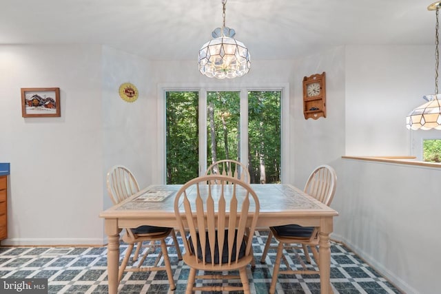  - dining room featuring a chandelier and baseboards