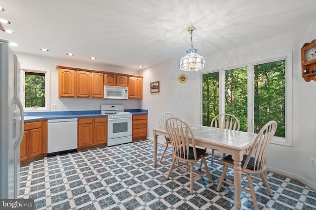  - kitchen with white appliances, light floors, a chandelier, pendant lighting, and baseboards