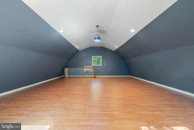  - additional living space with vaulted ceiling, light wood-style floors, a ceiling fan, and baseboards