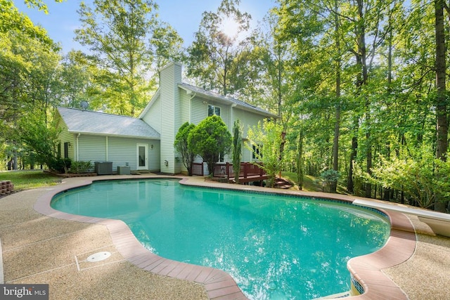  - swimming pool featuring central AC and a wooden deck