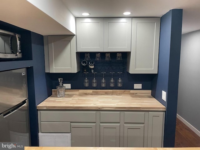  - kitchen featuring butcher block countertops, stainless steel appliances, wood finished floors, recessed lighting, and white cabinets