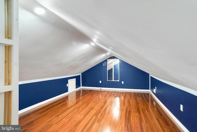  - bonus room with lofted ceiling, wood finished floors, and a textured ceiling