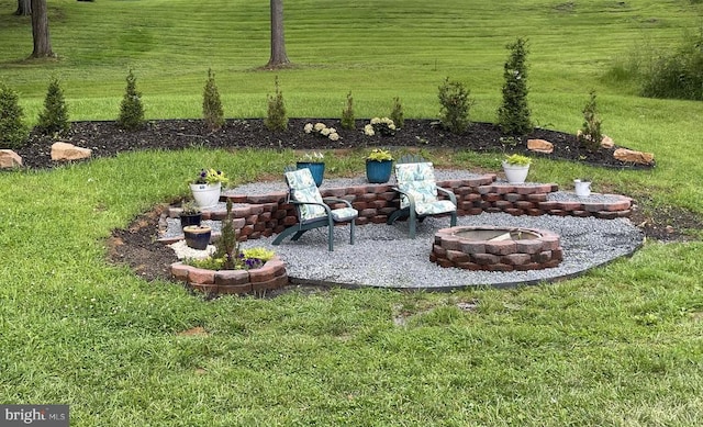  - view of grassy yard featuring an outdoor fire pit and a patio