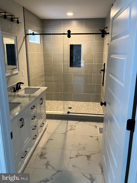 14400 Reva Rd, Reva, VA 22735 - full bath featuring a shower stall, double vanity, and marble look tiles