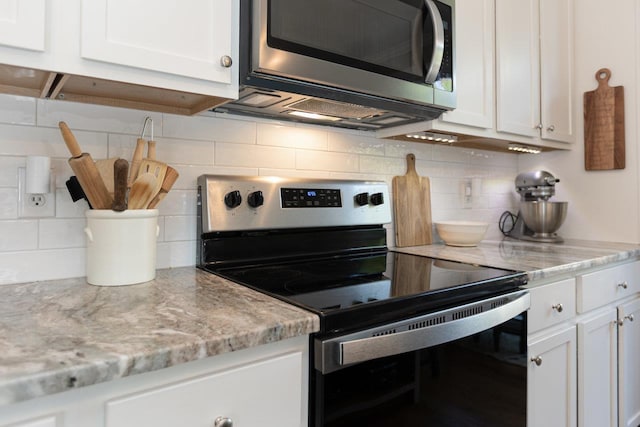 21 Spring View Dr, Staunton, VA 24401 - kitchen featuring appliances with stainless steel finishes, white cabinetry, decorative backsplash, and light stone counters