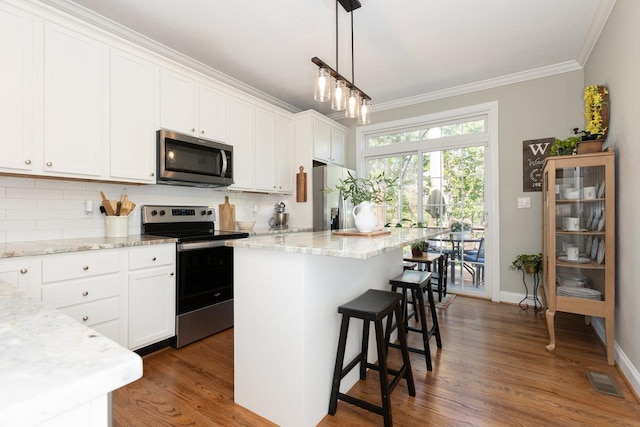 21 Spring View Dr, Staunton, VA 24401 - kitchen with appliances with stainless steel finishes, ornamental molding, decorative backsplash, dark wood-style flooring, and a kitchen bar