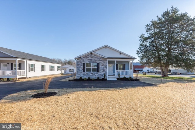 view of front of house featuring stone siding and a porch