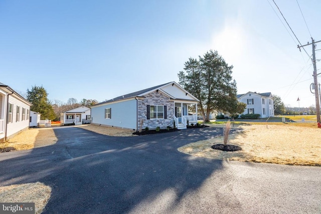 view of front of home with aphalt driveway and stone siding