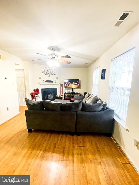 988 Towne Ln, Charlottesville, VA 22901 - living area with light wood-style flooring, a fireplace, ceiling fan, and baseboards