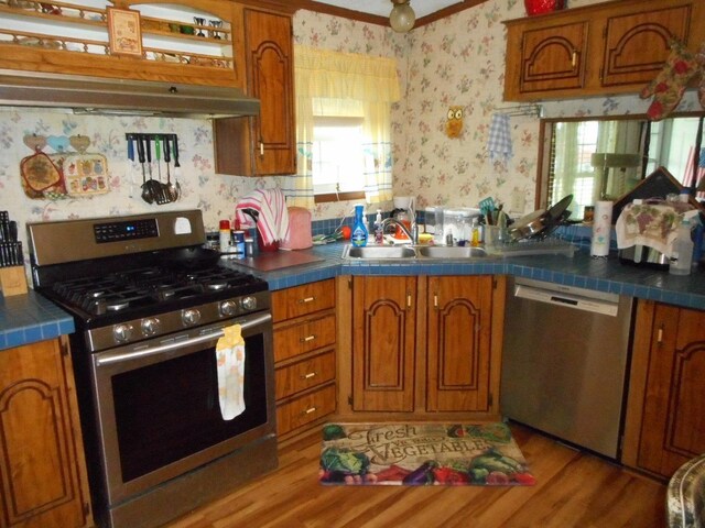 2780 Sunrise Dr, Broadway, VA 22815 - kitchen featuring appliances with stainless steel finishes, a sink, wallpapered walls, brown cabinets, and plenty of natural light