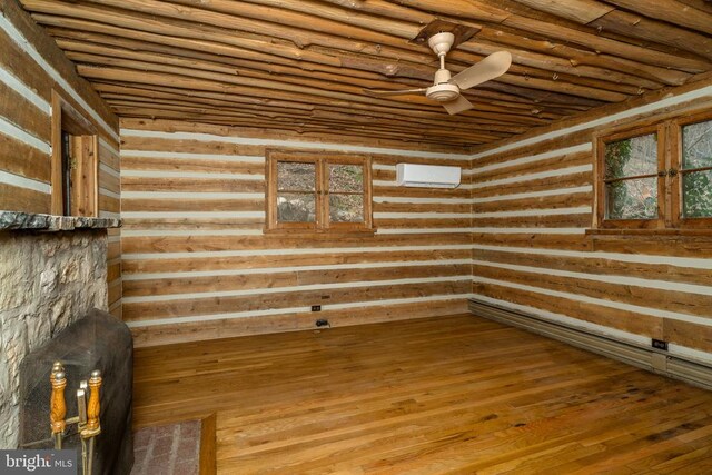 interior space with hardwood / wood-style floors, a wall mounted air conditioner, and ceiling fan