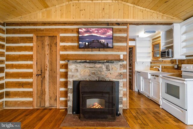 interior space with appliances with stainless steel finishes, hardwood / wood-style floors, a fireplace, sink, and wood ceiling