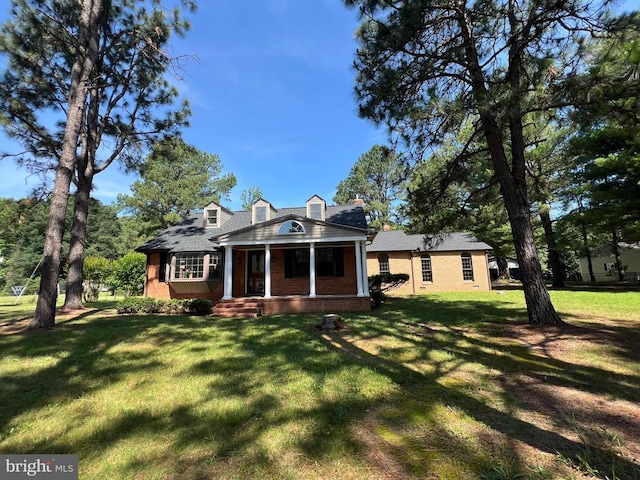 9872 Red Hill Rd, Spotsylvania, VA 22553 - new england style home with covered porch, brick siding, a front lawn, and a chimney