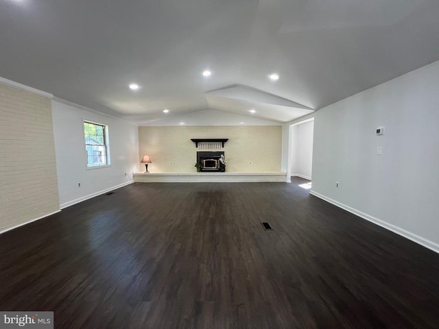9872 Red Hill Rd, Spotsylvania, VA 22553 - unfurnished living room with a brick fireplace, dark wood-style flooring, vaulted ceiling, brick wall, and recessed lighting