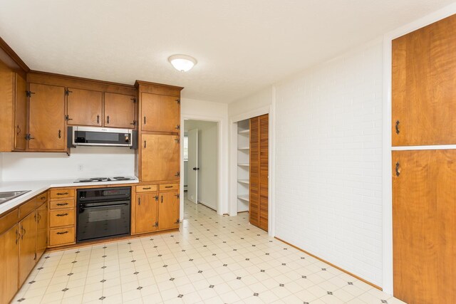 871 Kent Rd, Waynesboro, VA 22980 - kitchen featuring light flooring, black oven, stainless steel microwave, and brown cabinets